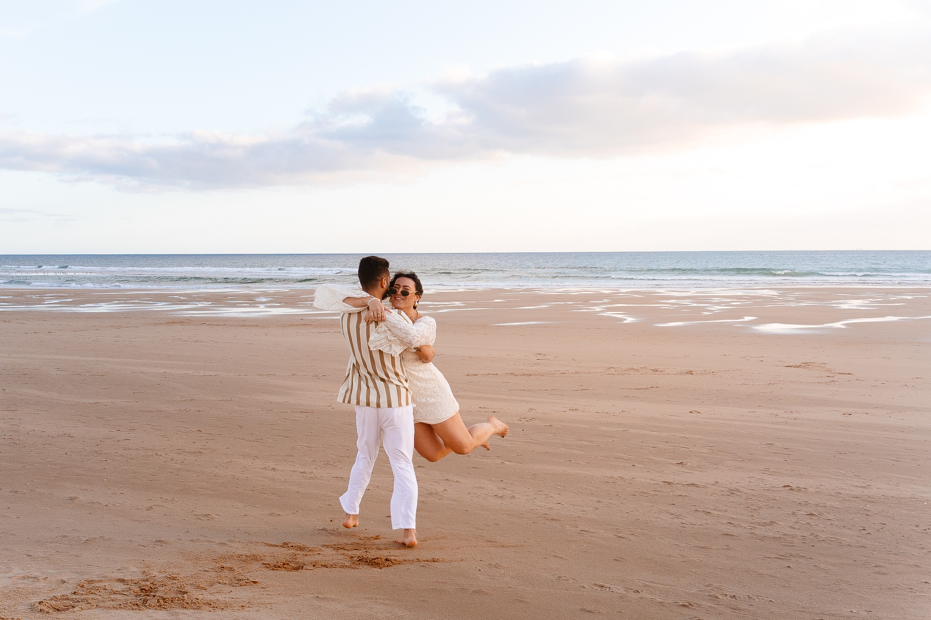Casal a dançar na praia ao pôr do sol